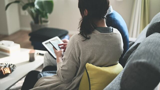 デジタル端末を見ながら相談をする夫婦