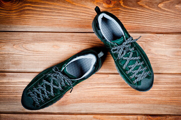Dark green suede shoes laced with laces. Close-up shot.