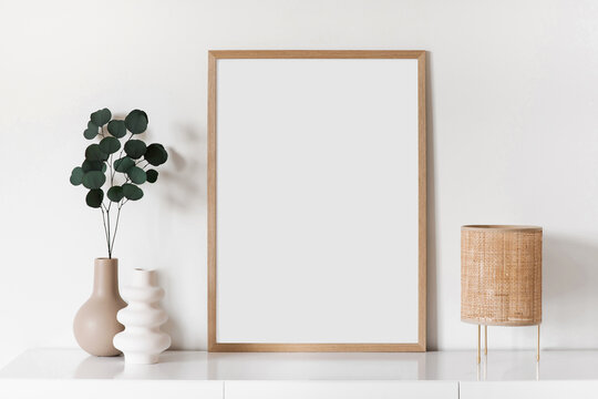 Blank picture frame mockup on white wall. Artwork in minimal interior design. View of modern style interior with canvas for painting, photo or poster on wall. Minimalism concept
