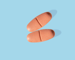 Orange tablets on a blue background, isolated, disease treatment concept, medicine, pharmacology, flat packaging, copy space