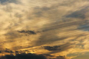空を飛行する夕日に染まった旅客機のシルエット「大阪空港」