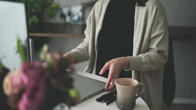ノートパソコンを持って席を立つ女性