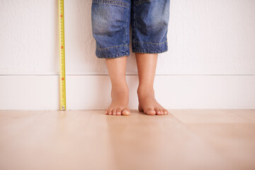 Getting taller by the day. Cropped shot of a young boy standing next to a tape measure.