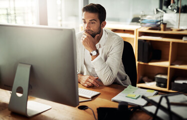 Hes never missed a deadline. Shot of a handsome young businessman working late on a computer in an office.