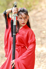 Young beautiful asian woman dressing in traditional Chinese old fashion warrior style with ancient...