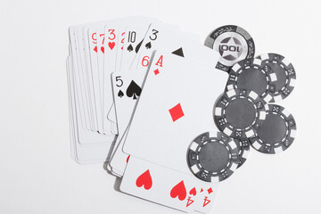 Playing cards of different suits and poker chips on a white background