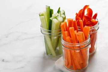 Vegetable sticks in glass jars. Carrot, cucumber, sweet pepper, paprika. Healthy food..