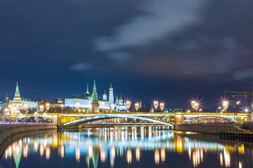 Fototapeta na wymiar Illuminated Moscow Kremlin and Bolshoy Kamenny Bridge in the night. View from the Patriarshy pedestrian Bridge in Russia. Evening urban landscape in the blue hour