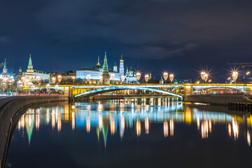 Obraz premium Illuminated Moscow Kremlin and Bolshoy Kamenny Bridge in the night. View from the Patriarshy pedestrian Bridge in Russia. Evening urban landscape in the blue hour
