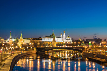 Obraz na płótnie Canvas Illuminated Moscow Kremlin and Bolshoy Kamenny Bridge in the night. View from the Patriarshy pedestrian Bridge in Russia. Evening urban landscape in the blue hour