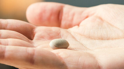 Close up of withe pills on hand