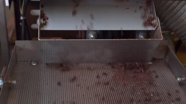 Cacao Nibs Dropping Onto Winnowing Machine In An Artisan Chocolate Factory. close up