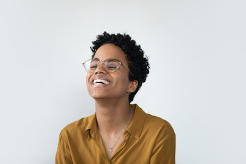 Cheerful excited pretty young African business woman in casual stylish glasses posing isolated on white, smiling, laughing, showing perfect white teeth. Happy female isolated head shot portrait