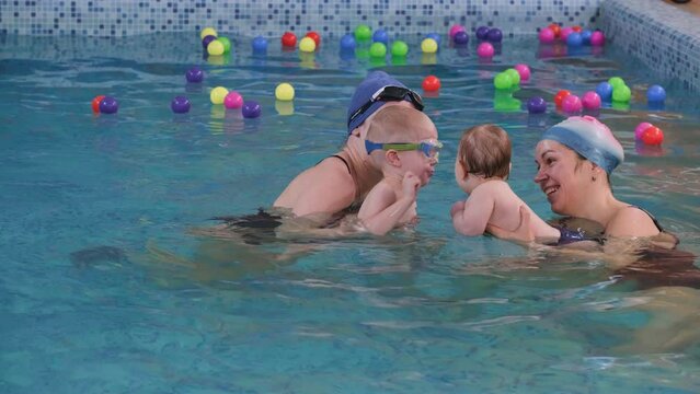 Kids Learning To Swim In Indoor Swimming Pool With Teacher. Happy Time Together And General Physical Activity For Kids, Early Development. Boy Children Early Development. Splash, Jump