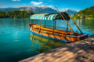 Anchored Pletna boat and castle in background, Bled, Slovenia