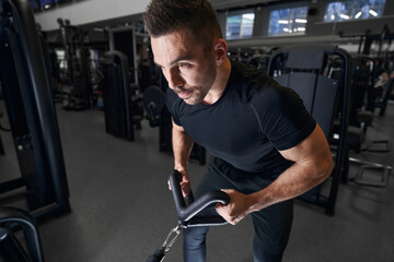 Serious sportsman using simulator during physical training