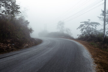 Obraz na płótnie Canvas Asphalt road in a fog in the mountains