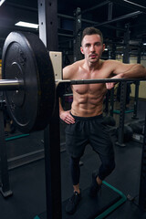 Fototapeta na wymiar Handsome male person leaning on the barbell