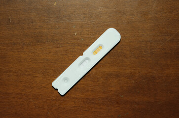 A picture of covid-19 self test kit showing positive result on the table