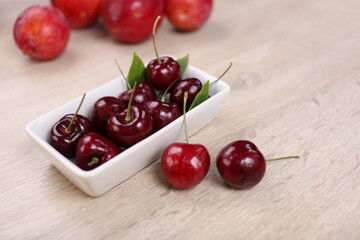 Obraz na płótnie Canvas Fresh cherry in white dish on wooden background