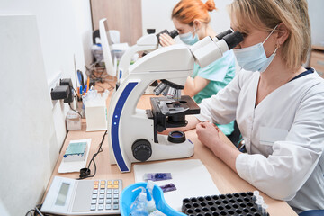 Medical workers in the laboratory with microscopes