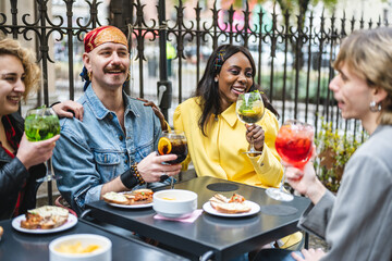 People drinking and talking sitting on a table outdoors, lgbt community having fun, diverse people and social inclusion