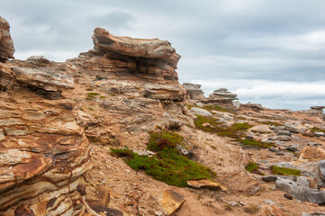 Big boulders of red rock against the dramatic sky background