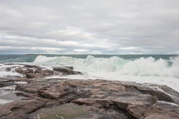 Dramatic scene with Sea waves crashing on big rocks.