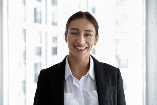 Head shot portrait of smiling beautiful young Caucasian ambitious businesswoman worker in formal wear. Profile photo of attractive 30s female team leader manager employee or company representative.
