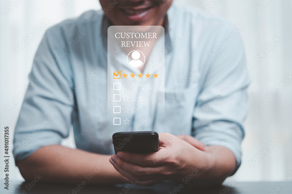 Poster Businessman using smartphone for select smiley face icon for client evaluation and customer satisfaction after use product and service concept.