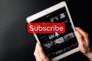 Subscription plan. Red online video subscribe button. Internet service on laptop digital tablet blured technology background. Visual contents concept. Social networking service.