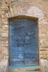 Wooden front door of the citadel in St. Florent, Corsica Island, France