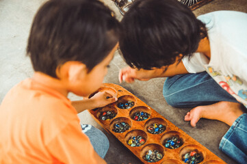 Kids playing traditional game name Congkak.