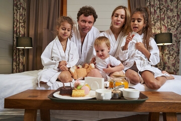 Mom, dad and children preparing for breakfast