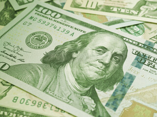 American paper money. A $100 bill with focus on eyes of Benjamin Franklin. US banknotes close-up. Business economy and the USA dollar. Light green tinted background. Macro
