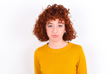 young redhead girl wearing yellow sweater over white background crying desperate and depressed with tears on his eyes suffering pain and depression. Sad facial expression and emotion concept.