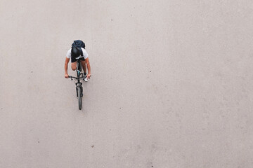 Cyclist with helmet and backpack on cement background