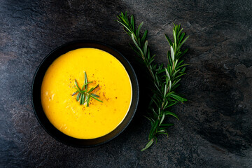 Pumpkin soup with linen napkin on dark background.