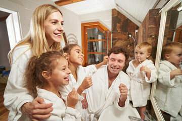 Obraz na płótnie Canvas Portrait of cheerful dad,mom and children having fun at home