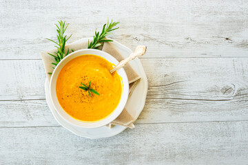 Pumpkin soup with linen napkin on light background.