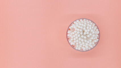 Cotton buds in box on a white background, Top view flat lay swabs cotton buds on orange background with copy space.