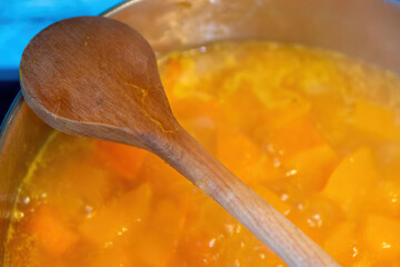 a wooden cooking spoon over a pumpkin stew