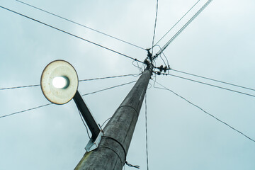 Street electric pole with many electrical wires and fiber optic cables