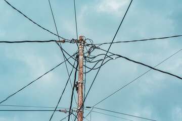 Street electric pole with many electrical wires and fiber optic cables