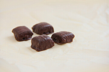 handmade chocolate. Bitter chocolate. Chocolates on parchment paper on a light background