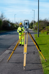Site engineer checking levels of the road using autolevel
