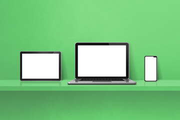 Laptop, mobile phone and digital tablet pc on green wall shelf. Horizontal background
