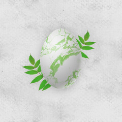Marbling egg with green spring leaves on old white paper texture. Spring Easter pysanka. 