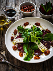 Beetroot carpaccio with goat cheese and pecan nuts  on wooden background
