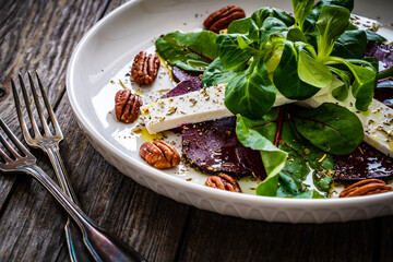 Beetroot carpaccio with goat cheese and pecan nuts  on wooden background
